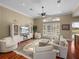 Bright living room featuring wood floors, neutral furniture, and a decorative rug at 13854 Thoroughbred Dr, Dade City, FL 33525