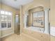 Elegant bathroom featuring a tiled tub, shower, and abundant natural light at 13854 Thoroughbred Dr, Dade City, FL 33525