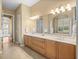 Spacious bathroom with double vanity, large mirror and doorway to the main bedroom at 13854 Thoroughbred Dr, Dade City, FL 33525