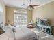 Well-lit bedroom showcases hardwood floors, a ceiling fan, and a charming decor arrangement with a blue accent at 13854 Thoroughbred Dr, Dade City, FL 33525