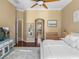 Bright main bedroom with ceiling fan, decorative mirror and doorway to the main bathroom at 13854 Thoroughbred Dr, Dade City, FL 33525