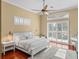 Serene main bedroom featuring hardwood floors, a ceiling fan, and sliding glass doors to the outdoor space at 13854 Thoroughbred Dr, Dade City, FL 33525