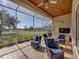 Covered patio featuring comfortable blue chairs, a fan, and an inviting outdoor space at 13854 Thoroughbred Dr, Dade City, FL 33525