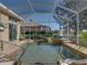 Screened-in pool area with charming lighthouse detail and golf course view beyond at 13854 Thoroughbred Dr, Dade City, FL 33525