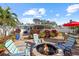 Paver patio featuring a fire pit, seating, dining table, and landscaping, a perfect backyard space for outdoor gatherings at 1658 St Mary Dr, Dunedin, FL 34698