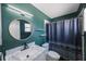 Stylish bathroom featuring an accent wall, modern lighting, and a round mirror at 1937 Palm Dr, Clearwater, FL 33763