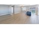 Bright open-concept living space with wood-look tile flooring, a hanging light fixture, and sliding doors to the pool at 1937 Palm Dr, Clearwater, FL 33763