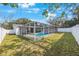 Backyard view of a screened pool with a well-maintained green lawn, perfect for outdoor enjoyment and entertaining at 1937 Palm Dr, Clearwater, FL 33763