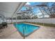 Refreshing screened-in pool features a metal ladder for easy access, with a concrete deck, perfect for relaxation and outdoor activities at 1937 Palm Dr, Clearwater, FL 33763