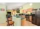 The kitchen includes a breakfast bar, light wood cabinets, stainless steel appliances, and adjacent living spaces at 2259 Renton Ln, Spring Hill, FL 34609