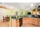 Kitchen with a view of the dining area, featuring wood cabinets, a breakfast bar, and stainless steel appliances at 2259 Renton Ln, Spring Hill, FL 34609