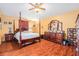 Spacious bedroom with a four-poster bed, a large dresser, and wood floors at 2259 Renton Ln, Spring Hill, FL 34609