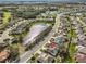 Aerial view of a residential neighborhood featuring mature trees and a scenic pond at 2449 E Del Webb Blvd, Sun City Center, FL 33573