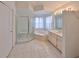 Bright bathroom featuring tiled floors, a shower and a large soaking tub, and vanity storage at 2449 E Del Webb Blvd, Sun City Center, FL 33573