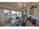 Dining room featuring a decorative glass table, chandelier, and sliding glass doors to the backyard at 2449 E Del Webb Blvd, Sun City Center, FL 33573