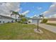 Well-maintained home features lush landscaping, a paved drive and sidewalk, and a two-car garage at 2449 E Del Webb Blvd, Sun City Center, FL 33573