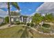 Charming single-story home with mature landscaping and a well-maintained lawn at 2449 E Del Webb Blvd, Sun City Center, FL 33573