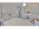 Bright white kitchen featuring white appliances, cabinets, pendant lighting and tile flooring at 2449 E Del Webb Blvd, Sun City Center, FL 33573