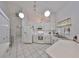 Bright white kitchen featuring white appliances and cabinets, pendant lighting and tile flooring at 2449 E Del Webb Blvd, Sun City Center, FL 33573