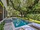 Beautiful backyard pool and lounge chairs surrounded by greenery and a mature shade tree at 2603 W Parkland Blvd, Tampa, FL 33609