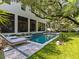 Backyard pool with manicured lawn, lounge chairs, a large shade tree and expansive backyard at 2603 W Parkland Blvd, Tampa, FL 33609
