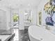 This bathroom features a free-standing tub, black marble tile floors, and a glass shower at 2603 W Parkland Blvd, Tampa, FL 33609