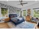 This bedroom has wood floors, windows, a ceiling fan, a blue bed, and wallpaper at 2603 W Parkland Blvd, Tampa, FL 33609