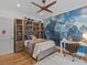 Well-lit bedroom with map mural, hardwood floors, and built-in bookshelf storage at 2603 W Parkland Blvd, Tampa, FL 33609