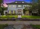 Elegant two-story home showcasing a beautifully landscaped front yard with a stone wall and charming double doors at 2603 W Parkland Blvd, Tampa, FL 33609