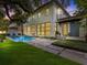 Exterior of home with a backyard pool, manicured lawn and a mature shade tree at 2603 W Parkland Blvd, Tampa, FL 33609