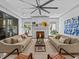 Symmetrical living room with sofas facing each other, a marble fireplace, and a large ceiling fan at 2603 W Parkland Blvd, Tampa, FL 33609