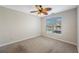 Bedroom featuring neutral carpet, a ceiling fan, and a window view of the building across the street at 2747 Via Capri # 1122, Clearwater, FL 33764