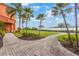 Well-maintained grounds with lush green grass, walkways, palm trees, and a waterfront view at 2747 Via Capri # 1122, Clearwater, FL 33764