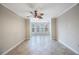 Bright living room boasts tile floors, large windows, and stylish ceiling fan at 2747 Via Capri # 1122, Clearwater, FL 33764