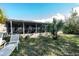 Relaxing outdoor space with screened-in porch, patio furniture, and a lush backyard at 3054 Bright Dr, Holiday, FL 34691