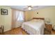 Comfortable bedroom features a ceiling fan, wood floors, and large windows at 3054 Bright Dr, Holiday, FL 34691
