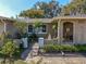 Inviting front entrance with wrought iron gate, mature landscaping, and charming architectural details at 3054 Bright Dr, Holiday, FL 34691