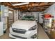 Well-lit garage space with car, storage shelves, and door opener provides ample storage and parking at 3054 Bright Dr, Holiday, FL 34691
