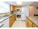 Traditional kitchen features wooden cabinets, granite countertops, and white appliances at 3054 Bright Dr, Holiday, FL 34691