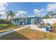 The blue house features a grill, a concrete patio and a garden at 411 Alma Dr, Brandon, FL 33510