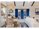 Bright dining area with wooden table, wicker chairs, and eye-catching blue accent wall at 4919 Chancellor Ne St, St Petersburg, FL 33703