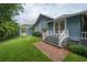 Charming backyard featuring a pergola, lush greenery, brick patio, and stairs to enter the home at 5114 N Branch Ave, Tampa, FL 33603