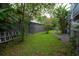 Serene backyard featuring lush green grass and mature trees, offering a private outdoor space at 5114 N Branch Ave, Tampa, FL 33603