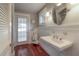 Cozy bathroom featuring beadboard wainscoting, a pedestal sink, and a large mirror at 5114 N Branch Ave, Tampa, FL 33603