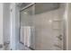 Clean bathroom featuring a shower with sliding glass doors and white tile surround at 5114 N Branch Ave, Tampa, FL 33603
