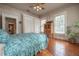 Bright bedroom with hardwood floors, multiple windows with light, and a decorative ship on a cabinet at 5114 N Branch Ave, Tampa, FL 33603