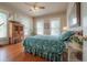 Comfortable bedroom featuring a floral comforter, wood floors, and bright natural lighting at 5114 N Branch Ave, Tampa, FL 33603