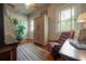 Cozy bedroom featuring wood floors, a cushioned chair, and natural light from the windows at 5114 N Branch Ave, Tampa, FL 33603