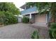 Home featuring a gravel driveway leading to a garage, surrounded by mature landscaping at 5114 N Branch Ave, Tampa, FL 33603