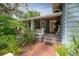 Charming front porch with brick steps, a pink door, ceiling fan and lush landscaping at 5114 N Branch Ave, Tampa, FL 33603